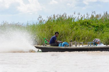 Inle Lake, Myanmar - 30 Ağustos 2016: Myanmar'ın Shan Eyaletinin Taunggyi İlçesi'nin Nyaungshwe İlçesi'nde bulunan bir tatlı su gölü olan Inle Sap'ın üzerinde bambu teknede bulunan tanımlanamayan Birmanyalı adam