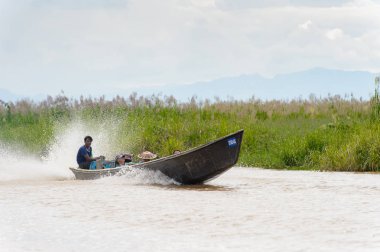 Inle Lake, Myanmar - 30 Ağustos 2016: Myanmar'ın Shan Eyaletinin Taunggyi İlçesi'nin Nyaungshwe İlçesi'nde bulunan bir tatlı su gölü olan Inle Sap'ın üzerinde bambu teknede bulunan tanımlanamayan Birmanyalı adam