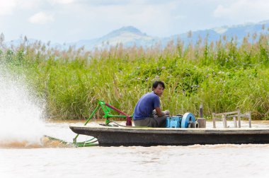 Inle Lake, Myanmar - 30 Ağustos 2016: Myanmar'ın Shan Eyaletinin Taunggyi İlçesi'nin Nyaungshwe İlçesi'nde bulunan bir tatlı su gölü olan Inle Sap'ın üzerinde bambu teknede bulunan tanımlanamayan Birmanyalı adam