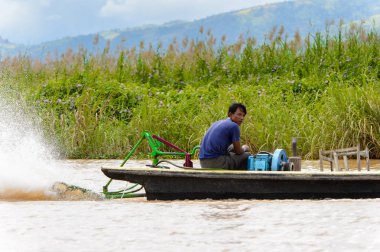 Inle Lake, Myanmar - 30 Ağustos 2016: Myanmar'ın Shan Eyaletinin Taunggyi İlçesi'nin Nyaungshwe İlçesi'nde bulunan bir tatlı su gölü olan Inle Sap'ın üzerinde bambu teknede bulunan tanımlanamayan Birmanyalı adam
