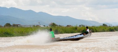 Inle Lake, Myanmar - 30 Ağustos 2016: Myanmar'ın Shan Eyaletinin Taunggyi İlçesi'nin Nyaungshwe İlçesi'nde bulunan bir tatlı su gölü olan Inle Sap'ın üzerinde bambu teknede bulunan tanımlanamayan Birmanyalı adam
