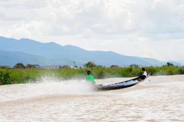 Inle Lake, Myanmar - 30 Ağustos 2016: Myanmar'ın Shan Eyaletinin Taunggyi İlçesi'nin Nyaungshwe İlçesi'nde bulunan bir tatlı su gölü olan Inle Sap'ın üzerinde bambu teknede bulunan tanımlanamayan Birmanyalı adam