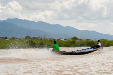 Inle Lake, Myanmar - 30 Ağustos 2016: Myanmar'ın Shan Eyaletinin Taunggyi İlçesi'nin Nyaungshwe İlçesi'nde bulunan bir tatlı su gölü olan Inle Sap'ın üzerinde bambu teknede bulunan tanımlanamayan Birmanyalı adam