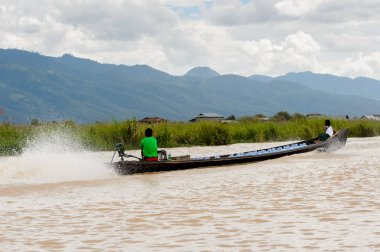 Inle Lake, Myanmar - 30 Ağustos 2016: Myanmar'ın Shan Eyaletinin Taunggyi İlçesi'nin Nyaungshwe İlçesi'nde bulunan bir tatlı su gölü olan Inle Sap'ın üzerinde bambu teknede bulunan tanımlanamayan Birmanyalı adam