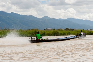 Inle Lake, Myanmar - 30 Ağustos 2016: Myanmar'ın Shan Eyaletinin Taunggyi İlçesi'nin Nyaungshwe İlçesi'nde bulunan bir tatlı su gölü olan Inle Sap'ın üzerinde bambu teknede bulunan tanımlanamayan Birmanyalı adam