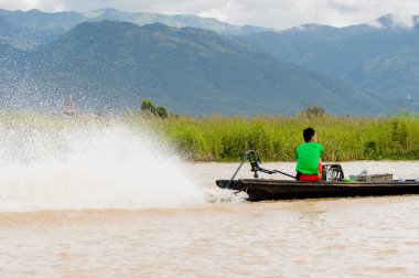 Inle Lake, Myanmar - 30 Ağustos 2016: Myanmar'ın Shan Eyaletinin Taunggyi İlçesi'nin Nyaungshwe İlçesi'nde bulunan bir tatlı su gölü olan Inle Sap'ın üzerinde bambu teknede bulunan tanımlanamayan Birmanyalı adam