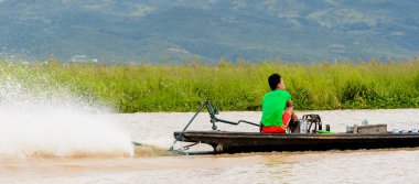 Inle Lake, Myanmar - 30 Ağustos 2016: Myanmar'ın Shan Eyaletinin Taunggyi İlçesi'nin Nyaungshwe İlçesi'nde bulunan bir tatlı su gölü olan Inle Sap'ın üzerinde bambu teknede bulunan tanımlanamayan Birmanyalı adam