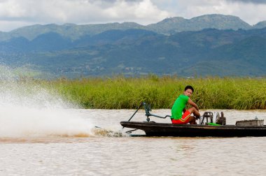 Inle Lake, Myanmar - 30 Ağustos 2016: Myanmar'ın Shan Eyaletinin Taunggyi İlçesi'nin Nyaungshwe İlçesi'nde bulunan bir tatlı su gölü olan Inle Sap'ın üzerinde bambu teknede bulunan tanımlanamayan Birmanyalı adam