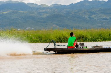 Inle Lake, Myanmar - 30 Ağustos 2016: Myanmar'ın Shan Eyaletinin Taunggyi İlçesi'nin Nyaungshwe İlçesi'nde bulunan bir tatlı su gölü olan Inle Sap'ın üzerinde bambu teknede bulunan tanımlanamayan Birmanyalı adam
