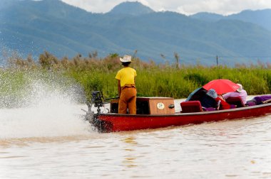 Inle Lake, Myanmar - 30 Ağustos 2016: Myanmar'ın Shan Eyaletinin Taunggyi İlçesi'nin Nyaungshwe İlçesi'nde bulunan bir tatlı su gölü olan Inle Sap'ın üzerinde bambu teknede bulunan tanımlanamayan Birmanyalı adam