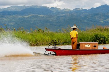 Inle Lake, Myanmar - 30 Ağustos 2016: Myanmar'ın Shan Eyaletinin Taunggyi İlçesi'nin Nyaungshwe İlçesi'nde bulunan bir tatlı su gölü olan Inle Sap'ın üzerinde bambu teknede bulunan tanımlanamayan Birmanyalı adam