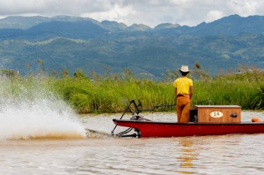 Inle Lake, Myanmar - 30 Ağustos 2016: Myanmar'ın Shan Eyaletinin Taunggyi İlçesi'nin Nyaungshwe İlçesi'nde bulunan bir tatlı su gölü olan Inle Sap'ın üzerinde bambu teknede bulunan tanımlanamayan Birmanyalı adam