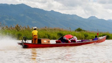 Inle Lake, Myanmar - 30 Ağustos 2016: Myanmar'ın Shan Eyaletinin Taunggyi İlçesi'nin Nyaungshwe İlçesi'nde bulunan bir tatlı su gölü olan Inle Sap'ın üzerinde bambu teknede bulunan tanımlanamayan Birmanyalı adam