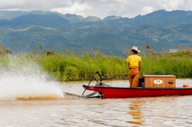Inle Lake, Myanmar - 30 Ağustos 2016: Myanmar'ın Shan Eyaletinin Taunggyi İlçesi'nin Nyaungshwe İlçesi'nde bulunan bir tatlı su gölü olan Inle Sap'ın üzerinde bambu teknede bulunan tanımlanamayan Birmanyalı adam