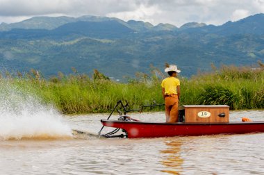 Inle Lake, Myanmar - 30 Ağustos 2016: Myanmar'ın Shan Eyaletinin Taunggyi İlçesi'nin Nyaungshwe İlçesi'nde bulunan bir tatlı su gölü olan Inle Sap'ın üzerinde bambu teknede bulunan tanımlanamayan Birmanyalı adam