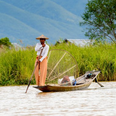 Inle Lake, Myanmar - 30 Ağustos 2016: Özel el yapımı ağı olan bir teknede tanımlanamayan Birmanyalı balıkçı. Bu Myanmar balıkçılık geleneksel yoludur