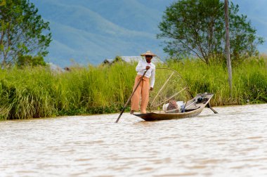 Inle Lake, Myanmar - 30 Ağustos 2016: Özel el yapımı ağı olan bir teknede tanımlanamayan Birmanyalı balıkçı. Bu Myanmar balıkçılık geleneksel yoludur