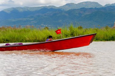 Inle Lake, Myanmar - 30 Ağustos 2016: Myanmar'ın Shan Eyaletinin Taunggyi İlçesi'nin Nyaungshwe İlçesi'nde bulunan bir tatlı su gölü olan Inle Sap'ın üzerinde bambu teknede bulunan tanımlanamayan Birmanyalı adam