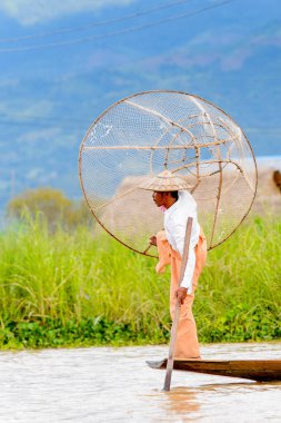Inle Lake, Myanmar - 30 Ağustos 2016: Özel el yapımı ağı olan bir teknede tanımlanamayan Birmanyalı balıkçı. Bu Myanmar balıkçılık geleneksel yoludur