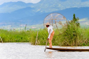 Inle Lake, Myanmar - 30 Ağustos 2016: Özel el yapımı ağı olan bir teknede tanımlanamayan Birmanyalı balıkçı. Bu Myanmar balıkçılık geleneksel yoludur