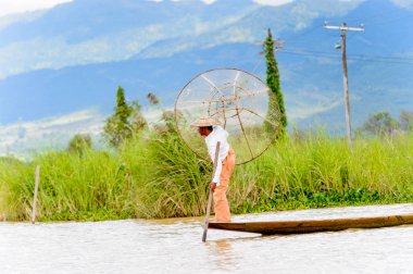 Inle Lake, Myanmar - 30 Ağustos 2016: Özel el yapımı ağı olan bir teknede tanımlanamayan Birmanyalı balıkçı. Bu Myanmar balıkçılık geleneksel yoludur