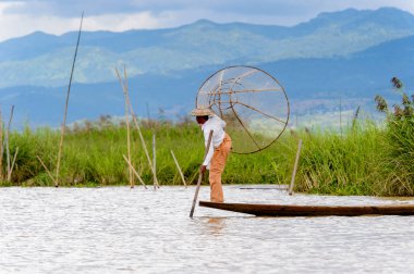 Inle Lake, Myanmar - 30 Ağustos 2016: Özel el yapımı ağı olan bir teknede tanımlanamayan Birmanyalı balıkçı. Bu Myanmar balıkçılık geleneksel yoludur