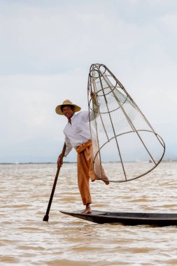 Inle Lake, Myanmar - 30 Ağustos 2016: Özel el yapımı ağı olan bir teknede tanımlanamayan Birmanyalı balıkçı. Bu Myanmar balıkçılık geleneksel yoludur
