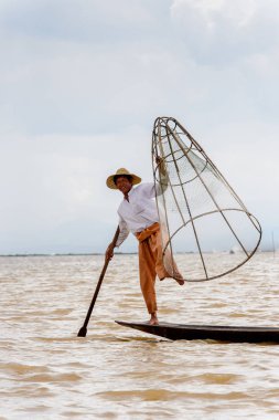 Inle Lake, Myanmar - 30 Ağustos 2016: Özel el yapımı ağı olan bir teknede tanımlanamayan Birmanyalı balıkçı. Bu Myanmar balıkçılık geleneksel yoludur