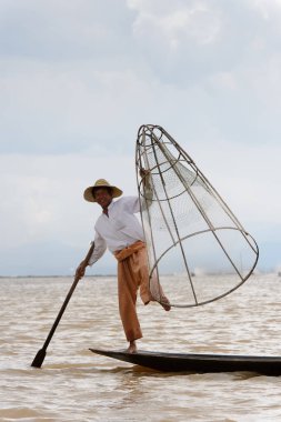 Inle Lake, Myanmar - 30 Ağustos 2016: Özel el yapımı ağı olan bir teknede tanımlanamayan Birmanyalı balıkçı. Bu Myanmar balıkçılık geleneksel yoludur