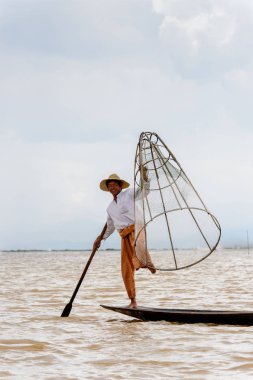 Inle Lake, Myanmar - 30 Ağustos 2016: Özel el yapımı ağı olan bir teknede tanımlanamayan Birmanyalı balıkçı. Bu Myanmar balıkçılık geleneksel yoludur