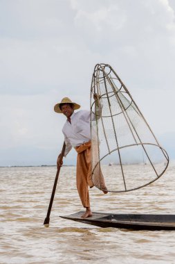 Inle Lake, Myanmar - 30 Ağustos 2016: Özel el yapımı ağı olan bir teknede tanımlanamayan Birmanyalı balıkçı. Bu Myanmar balıkçılık geleneksel yoludur