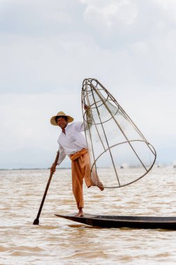 Inle Lake, Myanmar - 30 Ağustos 2016: Özel el yapımı ağı olan bir teknede tanımlanamayan Birmanyalı balıkçı. Bu Myanmar balıkçılık geleneksel yoludur