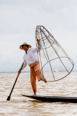 Inle Lake, Myanmar - 30 Ağustos 2016: Özel el yapımı ağı olan bir teknede tanımlanamayan Birmanyalı balıkçı. Bu Myanmar balıkçılık geleneksel yoludur
