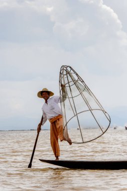 Inle Lake, Myanmar - 30 Ağustos 2016: Özel el yapımı ağı olan bir teknede tanımlanamayan Birmanyalı balıkçı. Bu Myanmar balıkçılık geleneksel yoludur