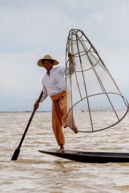 Inle Lake, Myanmar - 30 Ağustos 2016: Özel el yapımı ağı olan bir teknede tanımlanamayan Birmanyalı balıkçı. Bu Myanmar balıkçılık geleneksel yoludur