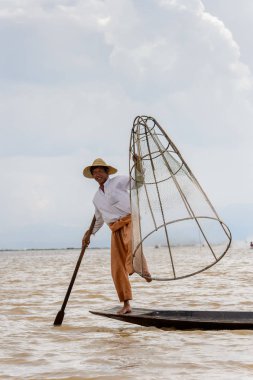 Inle Lake, Myanmar - 30 Ağustos 2016: Özel el yapımı ağı olan bir teknede tanımlanamayan Birmanyalı balıkçı. Bu Myanmar balıkçılık geleneksel yoludur