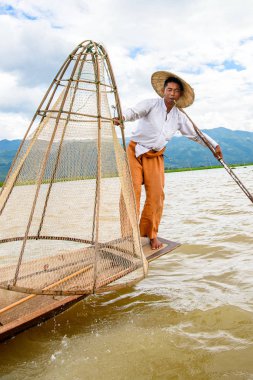 Inle Lake, Myanmar - 30 Ağustos 2016: Özel el yapımı ağı olan bir teknede tanımlanamayan Birmanyalı balıkçı. Bu Myanmar balıkçılık geleneksel yoludur