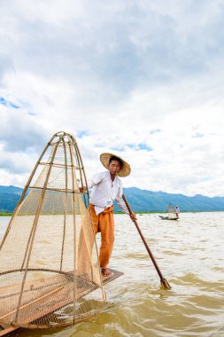 Inle Lake, Myanmar - 30 Ağustos 2016: Özel el yapımı ağı olan bir teknede tanımlanamayan Birmanyalı balıkçı. Bu Myanmar balıkçılık geleneksel yoludur