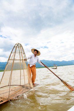 Inle Lake, Myanmar - 30 Ağustos 2016: Özel el yapımı ağı olan bir teknede tanımlanamayan Birmanyalı balıkçı. Bu Myanmar balıkçılık geleneksel yoludur