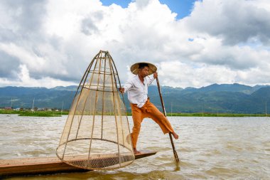 Inle Lake, Myanmar - 30 Ağustos 2016: Özel el yapımı ağı olan bir teknede tanımlanamayan Birmanyalı balıkçı. Bu Myanmar balıkçılık geleneksel yoludur