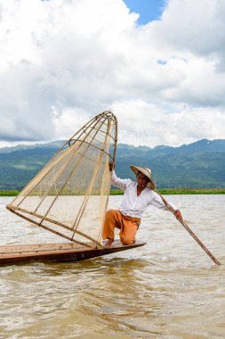 Inle Lake, Myanmar - 30 Ağustos 2016: Özel el yapımı ağı olan bir teknede tanımlanamayan Birmanyalı balıkçı. Bu Myanmar balıkçılık geleneksel yoludur