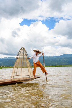 Inle Lake, Myanmar - 30 Ağustos 2016: Özel el yapımı ağı olan bir teknede tanımlanamayan Birmanyalı balıkçı. Bu Myanmar balıkçılık geleneksel yoludur