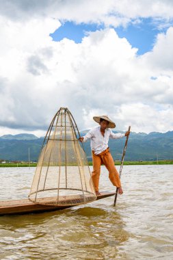 Inle Lake, Myanmar - 30 Ağustos 2016: Özel el yapımı ağı olan bir teknede tanımlanamayan Birmanyalı balıkçı. Bu Myanmar balıkçılık geleneksel yoludur