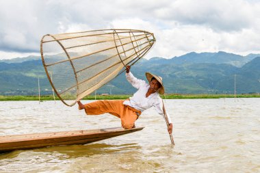 Inle Lake, Myanmar - 30 Ağustos 2016: Özel el yapımı ağı olan bir teknede tanımlanamayan Birmanyalı balıkçı. Bu Myanmar balıkçılık geleneksel yoludur