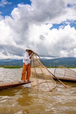 Inle Lake, Myanmar - 30 Ağustos 2016: Özel el yapımı ağı olan bir teknede tanımlanamayan Birmanyalı balıkçı. Bu Myanmar balıkçılık geleneksel yoludur
