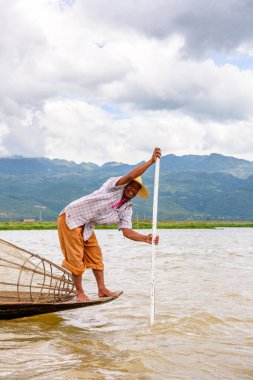 Inle Lake, Myanmar - 30 Ağustos 2016: Özel el yapımı ağı olan bir teknede tanımlanamayan Birmanyalı balıkçı. Bu Myanmar balıkçılık geleneksel yoludur