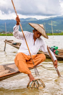 Inle Lake, Myanmar - 30 Ağustos 2016: Özel el yapımı ağı olan bir teknede tanımlanamayan Birmanyalı balıkçı. Bu Myanmar balıkçılık geleneksel yoludur