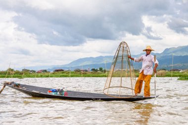 Inle Lake, Myanmar - 30 Ağustos 2016: Özel el yapımı ağı olan bir teknede tanımlanamayan Birmanyalı balıkçı. Bu Myanmar balıkçılık geleneksel yoludur