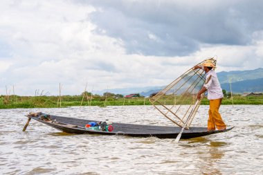 Inle Lake, Myanmar - 30 Ağustos 2016: Özel el yapımı ağı olan bir teknede tanımlanamayan Birmanyalı balıkçı. Bu Myanmar balıkçılık geleneksel yoludur