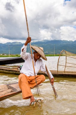 Inle Lake, Myanmar - 30 Ağustos 2016: Özel el yapımı ağı olan bir teknede tanımlanamayan Birmanyalı balıkçı. Bu Myanmar balıkçılık geleneksel yoludur